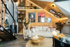 Stylish modern living room featuring rustic decor, hammock chair, and bookshelf for a cozy atmosphere.